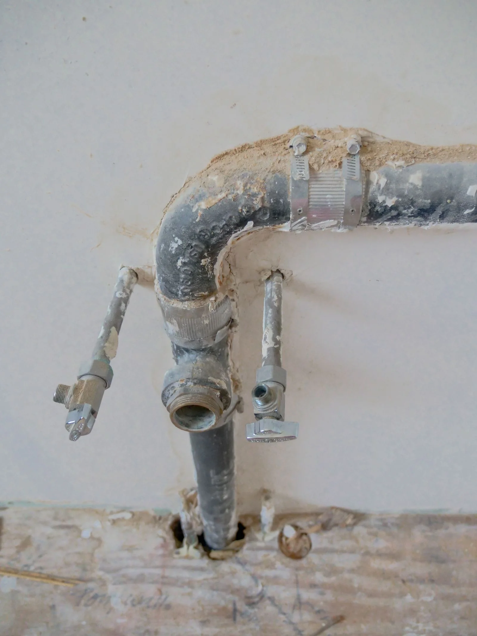 old galvanised steel water supply pipe and shutoff valves exposed in an opened wall during a pipe repair in Cleveland TN