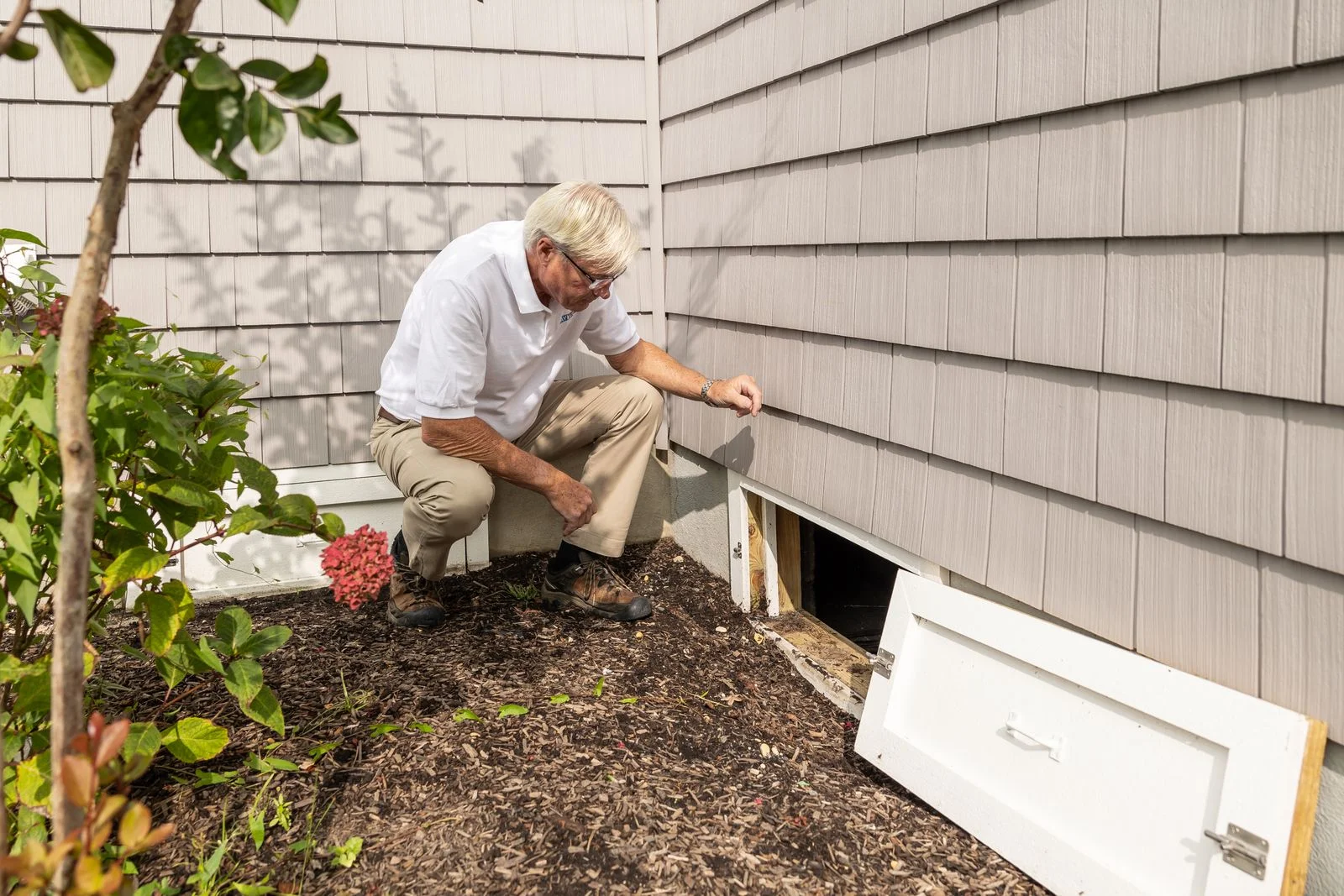 plumber mcdonald tn checking supply lines at a crawlspace vent on a rural home