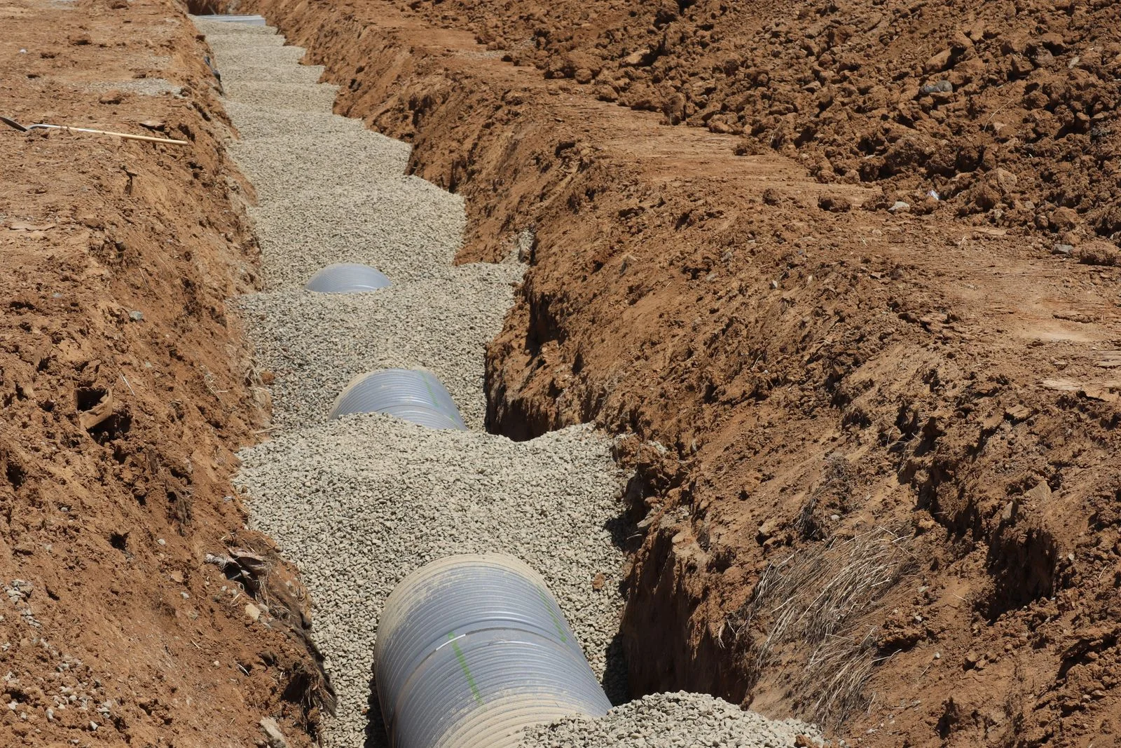 open trench with a drain line bedded in gravel during sewage drain cleaning cleveland tn