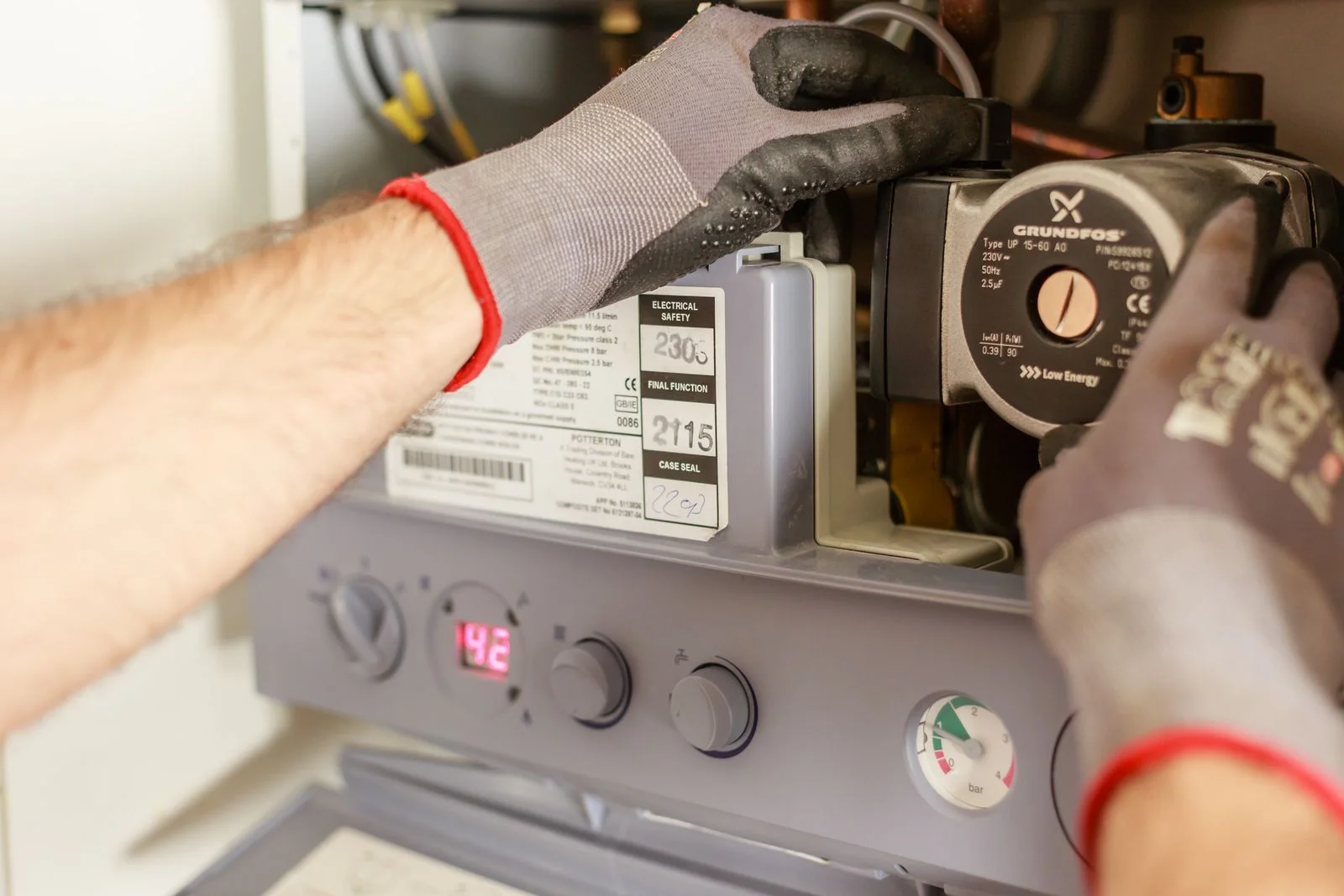 gloved hands checking controls and a pressure gauge during water heater repair cleveland tn
